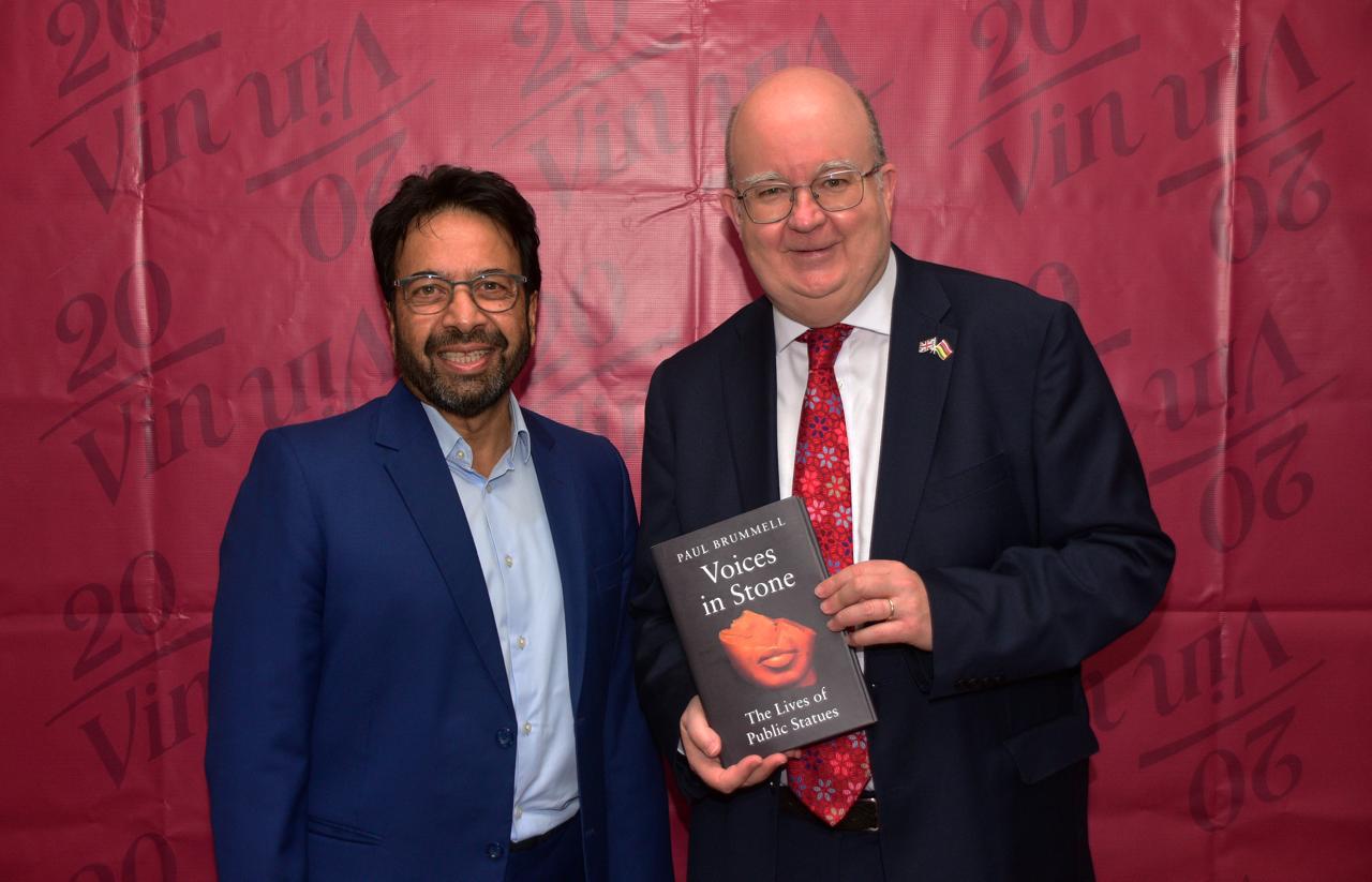 Author with a member holding 'Voices in Stone' at the book launch